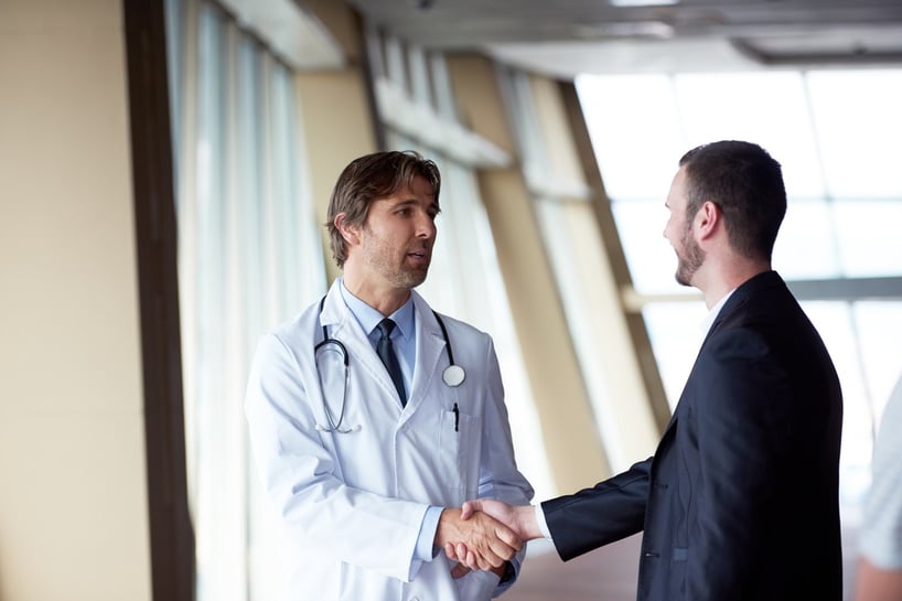doctor handshake with a patient at doctors bright modern office in hospital.jpeg