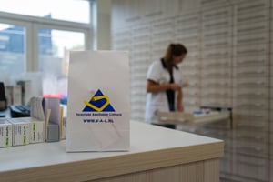 Een apotheker haalt de juiste medicijnen uit de kast.