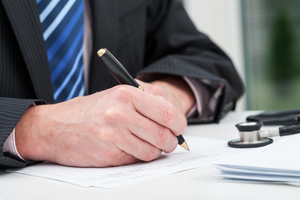 Closeup of a doctor's hands taking notes in his office