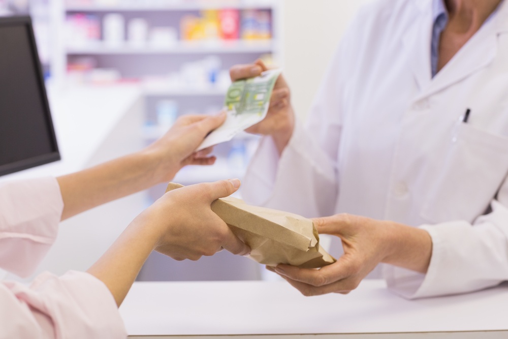 Pharmacist giving medicine to costumer at pharmacy