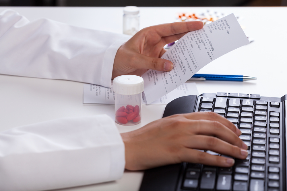 Pharmacist's hands checking information about medicines