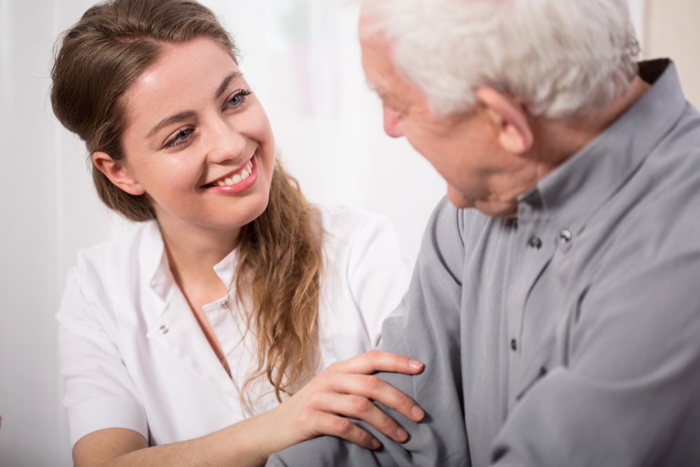 Picture of smiling nurse assisting senior man.jpeg