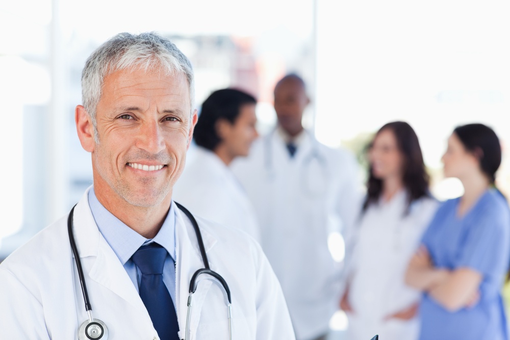 Smiling doctor waiting for his team while standing upright.jpeg