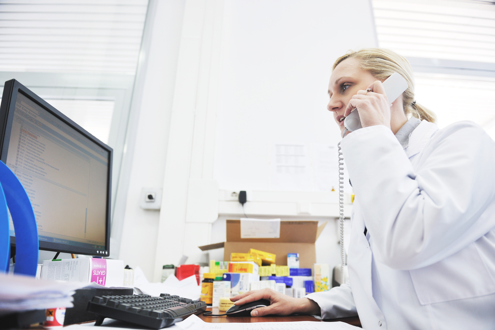 pharmacy worker talking by phone and typing and computer keyboard-1