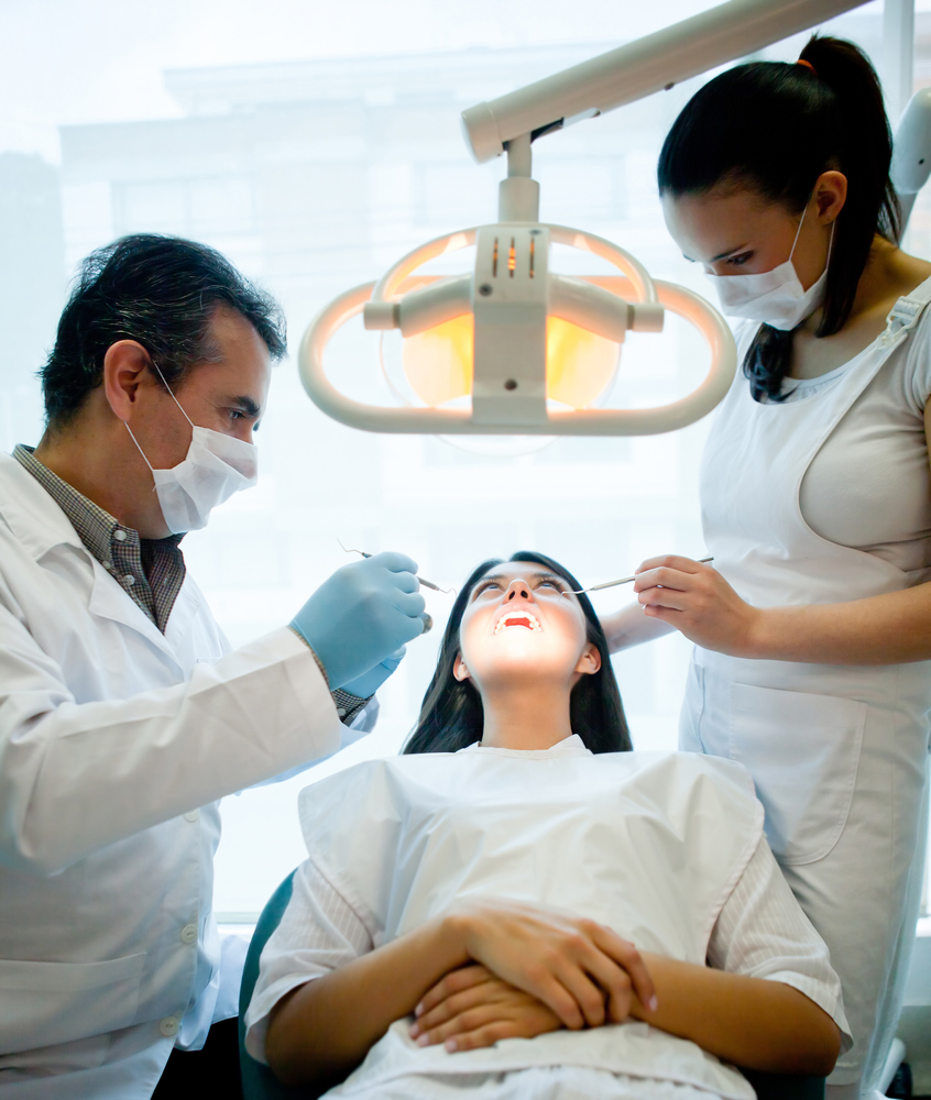Woman visiting the dentist and having a treatment done